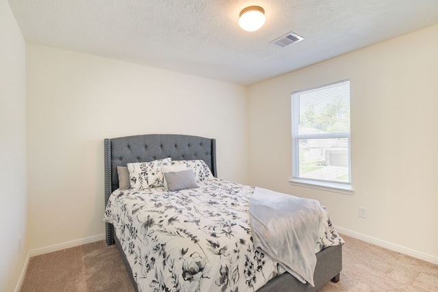 carpeted bedroom featuring a textured ceiling