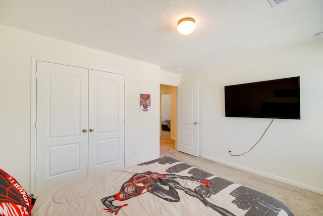 carpeted bedroom with a closet and a textured ceiling