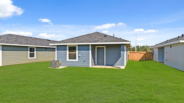 rear view of property with a lawn and central AC