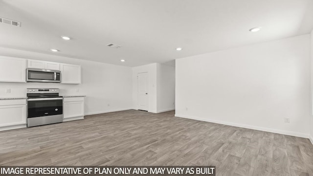 kitchen with white cabinets, light hardwood / wood-style flooring, and appliances with stainless steel finishes