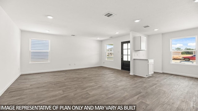 11938 Midas Ln, Willis, TX 77378 - unfurnished living room with wood finished floors, healthy amount of natural light, recessed lighting, and baseboards