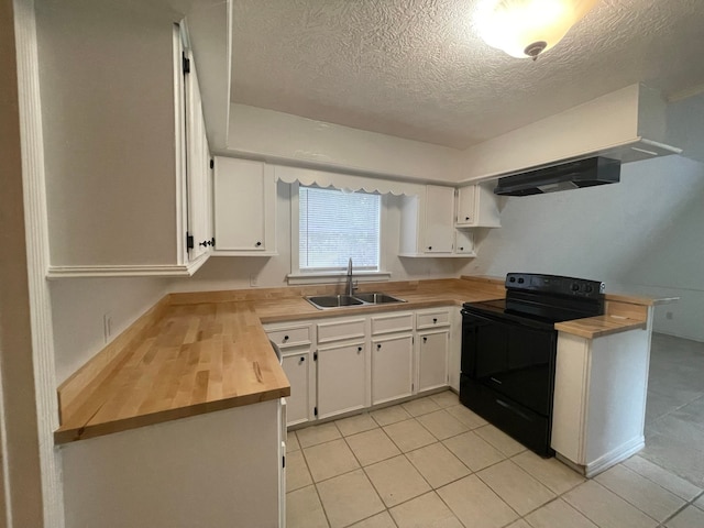 kitchen with white cabinets, sink, light tile patterned flooring, and electric range