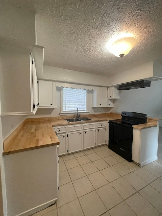 kitchen featuring white cabinetry, sink, light tile patterned floors, black range with electric cooktop, and wood counters