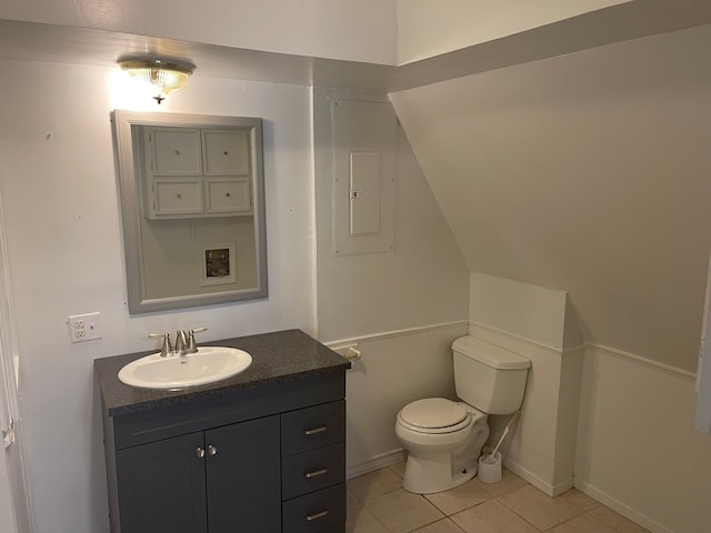 bathroom featuring toilet, electric panel, vanity, and tile patterned floors