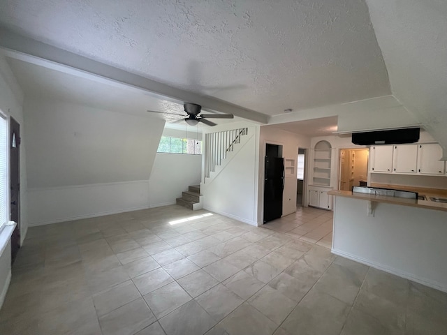 kitchen featuring white cabinetry, kitchen peninsula, ceiling fan, a textured ceiling, and black refrigerator