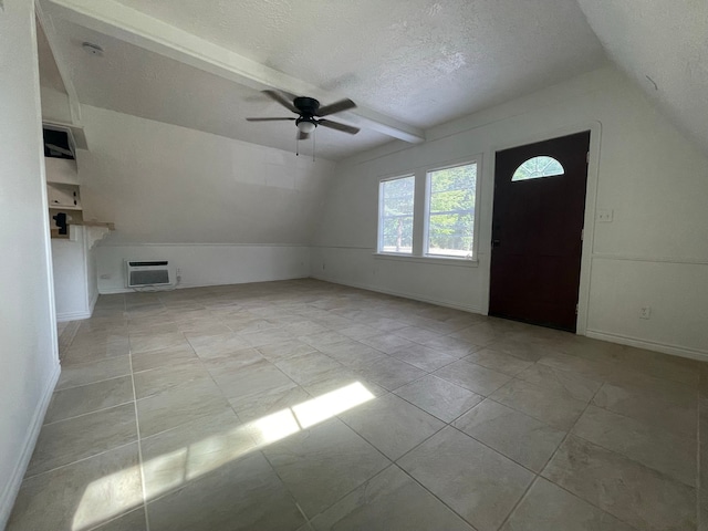 entryway with vaulted ceiling with beams, a textured ceiling, light tile patterned floors, a wall unit AC, and ceiling fan