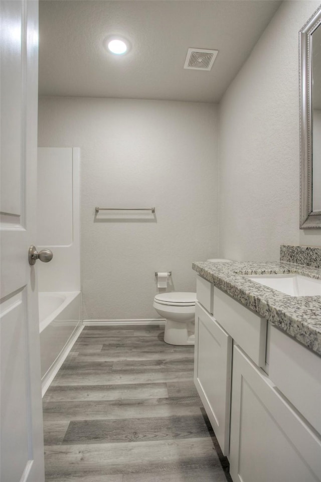 full bathroom featuring vanity, toilet, wood-type flooring, and shower / tub combination