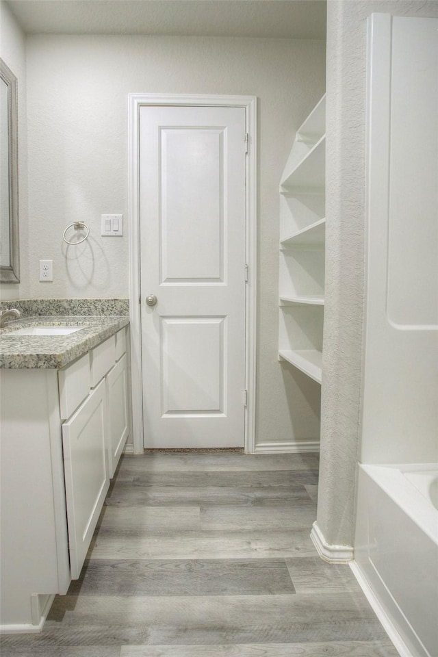 4 Big Lake Cir, Huntsville, TX 77320 - bathroom with vanity, a tub to relax in, wood finished floors, and baseboards