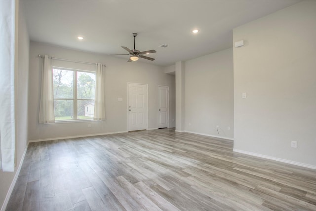 spare room with ceiling fan and light wood-type flooring