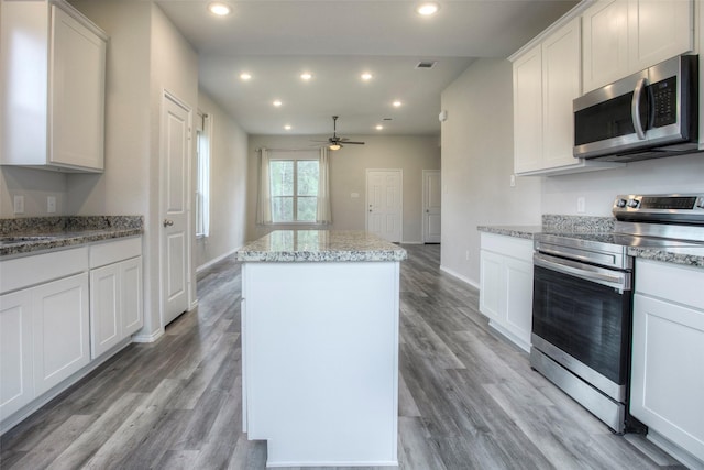 4 Big Lake Cir, Huntsville, TX 77320 - kitchen with stainless steel appliances, a center island, a ceiling fan, recessed lighting, and light wood-type flooring