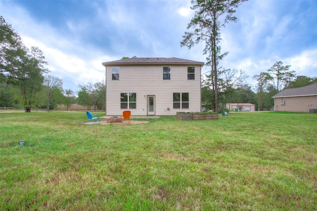 rear view of house with a yard, a patio, and an outdoor fire pit