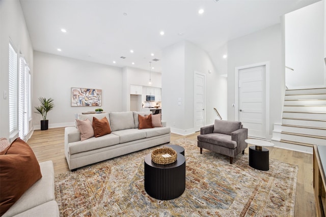 living area featuring light wood-style floors, stairs, and recessed lighting