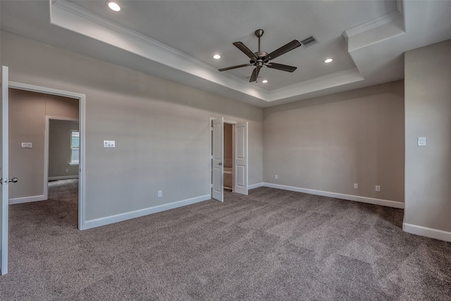 unfurnished room with ceiling fan, a raised ceiling, crown molding, and carpet