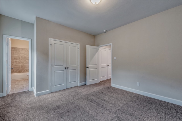 unfurnished bedroom with ensuite bath, light carpet, and a closet