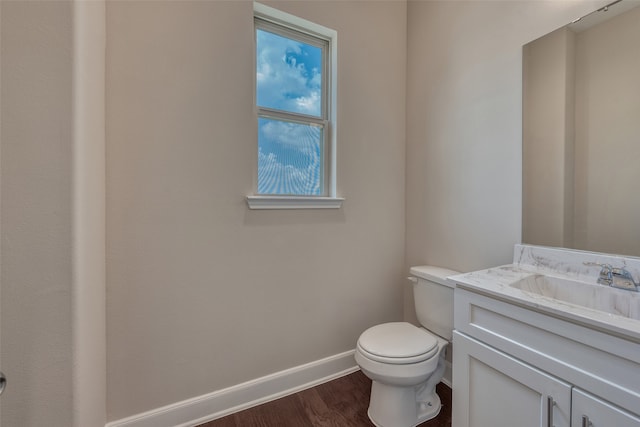 bathroom with wood-type flooring, toilet, and vanity