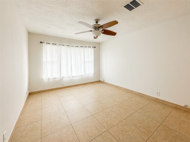 tiled spare room with a textured ceiling and ceiling fan