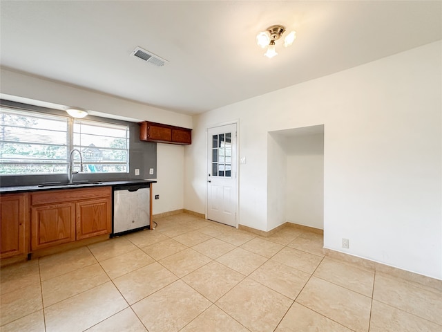 kitchen featuring dishwasher, sink, and light tile patterned flooring