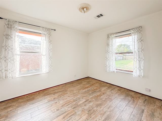 spare room featuring hardwood / wood-style flooring and a healthy amount of sunlight