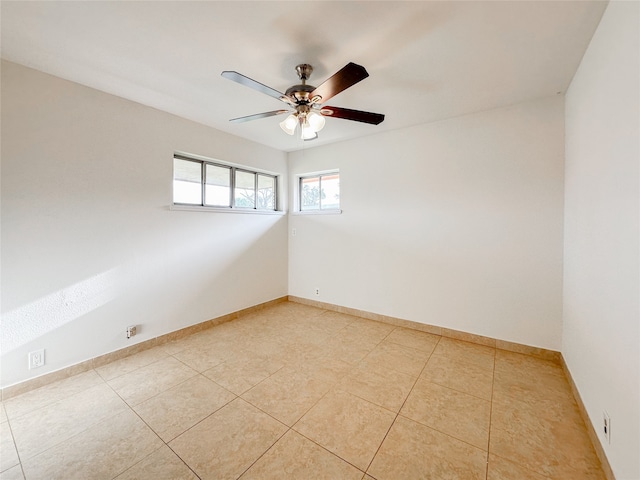 tiled empty room featuring ceiling fan