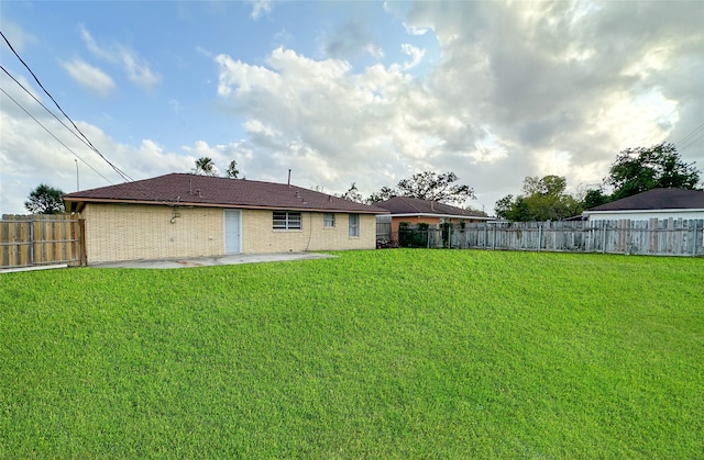 rear view of property with a yard and a patio area