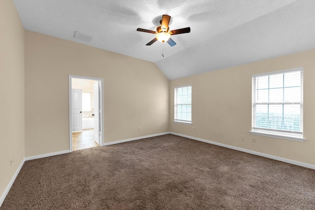 unfurnished room with ceiling fan, a textured ceiling, vaulted ceiling, and carpet