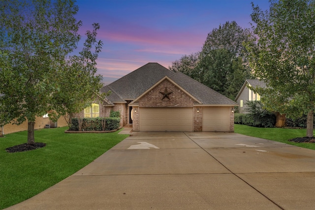 view of front facade with a garage and a yard