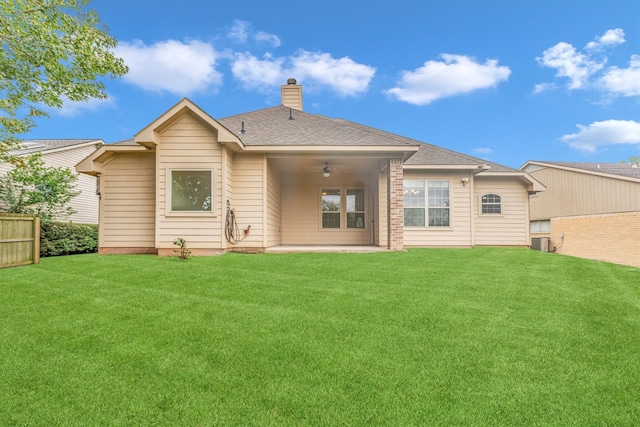 back of house featuring ceiling fan, a lawn, and central AC