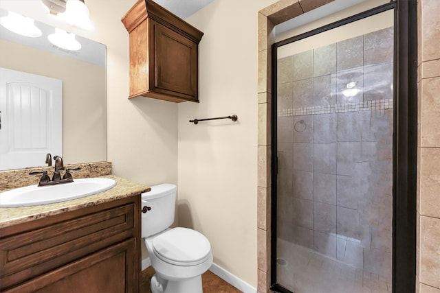 bathroom with a shower with door, vanity, and toilet