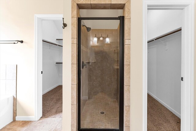 bathroom featuring a shower with shower door and tile patterned floors