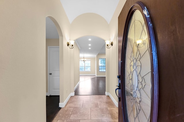 foyer featuring lofted ceiling, a notable chandelier, and light hardwood / wood-style flooring