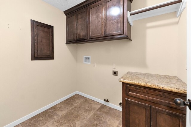 laundry area featuring gas dryer hookup, hookup for an electric dryer, washer hookup, a textured ceiling, and cabinets