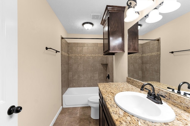 full bathroom with tile patterned flooring, tiled shower / bath, a textured ceiling, vanity, and toilet