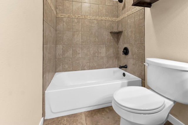 bathroom featuring tiled shower / bath combo and toilet