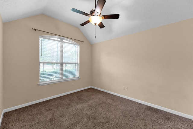 carpeted spare room with ceiling fan and vaulted ceiling