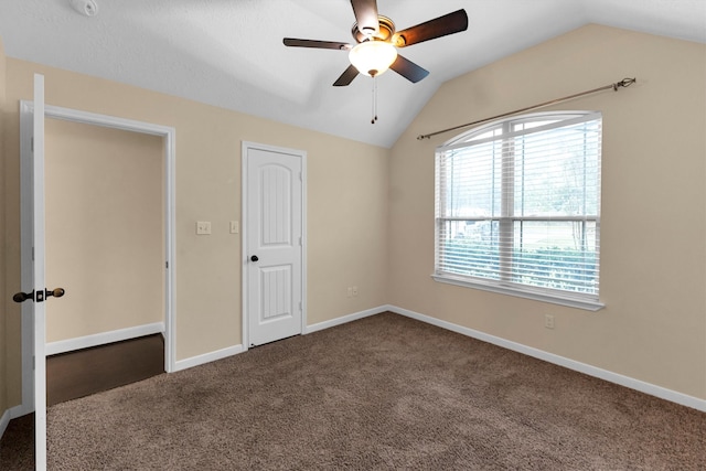 unfurnished bedroom with ceiling fan, vaulted ceiling, and carpet