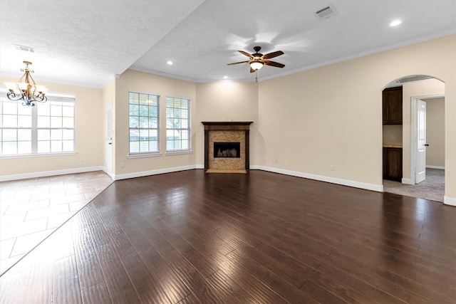 unfurnished living room with dark hardwood / wood-style flooring, a textured ceiling, ceiling fan with notable chandelier, and crown molding