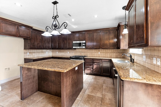 kitchen featuring stainless steel appliances, hanging light fixtures, sink, and a kitchen island