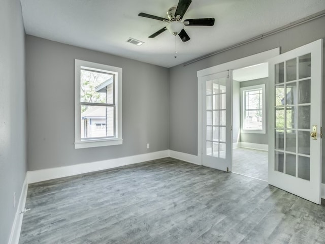 empty room featuring hardwood / wood-style floors, french doors, and ceiling fan