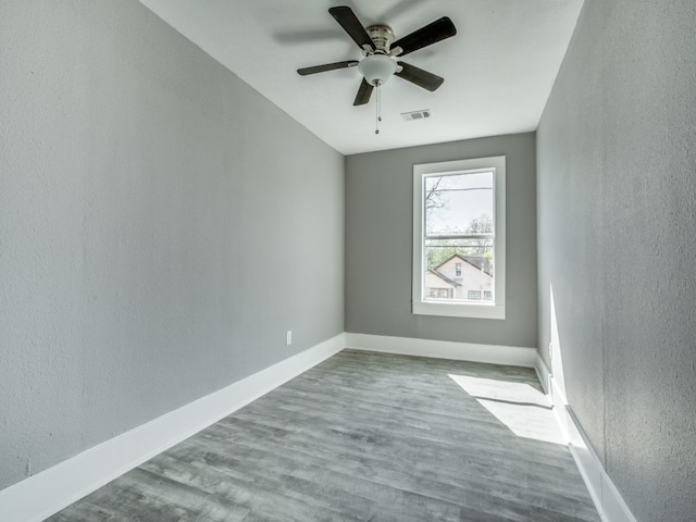 empty room with hardwood / wood-style flooring and ceiling fan