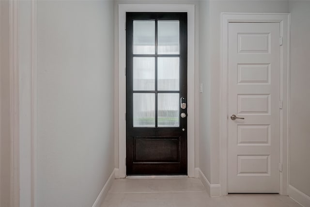 doorway to outside with light tile patterned floors