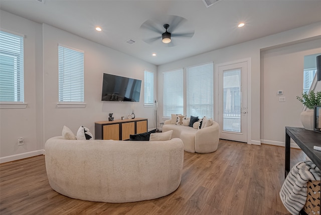 living room featuring a wealth of natural light, hardwood / wood-style flooring, and ceiling fan