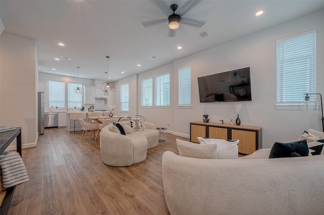 living room with ceiling fan and light hardwood / wood-style flooring