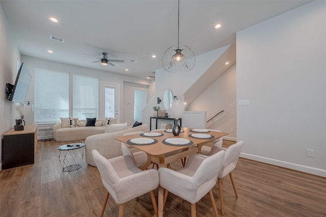 dining space with light hardwood / wood-style floors and ceiling fan with notable chandelier