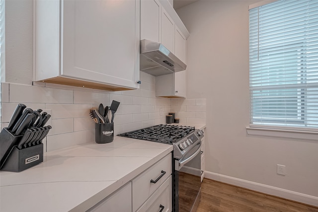 kitchen with white cabinetry, decorative backsplash, hardwood / wood-style flooring, and gas stove