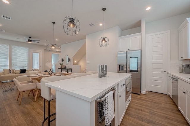 kitchen featuring light hardwood / wood-style flooring, stainless steel appliances, and white cabinets