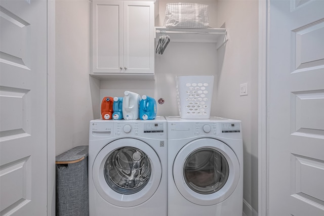 clothes washing area with cabinets and washing machine and clothes dryer