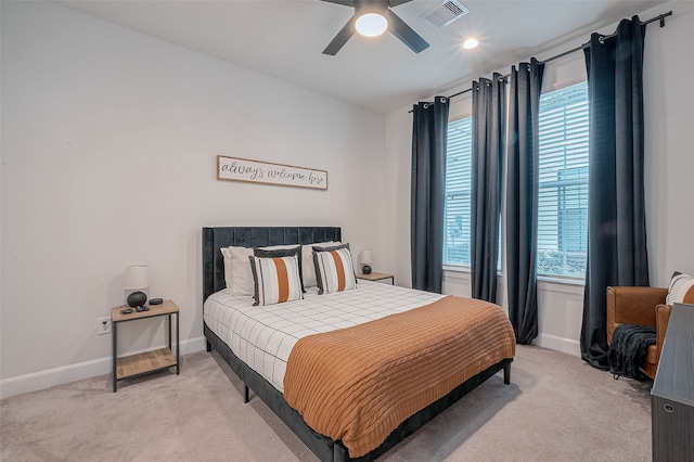 carpeted bedroom featuring multiple windows and ceiling fan