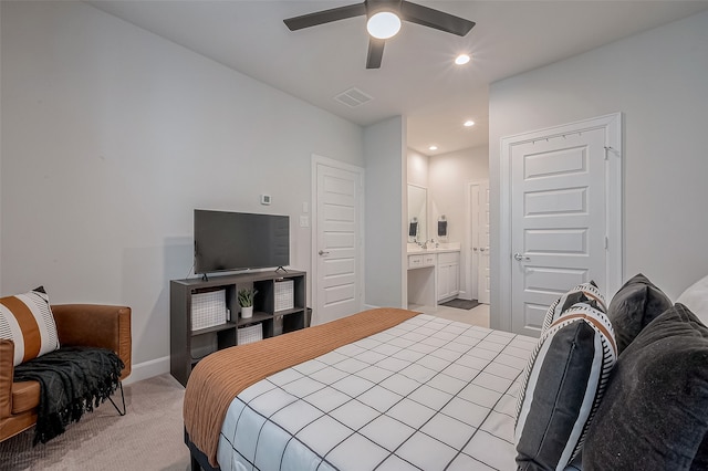 bedroom with light colored carpet, ceiling fan, and connected bathroom