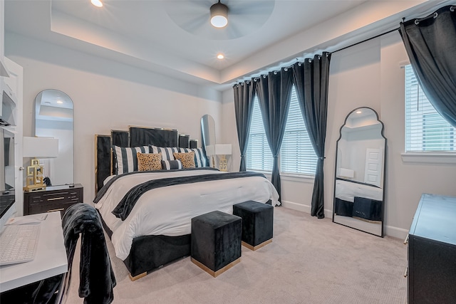 bedroom featuring ceiling fan, multiple windows, and light colored carpet