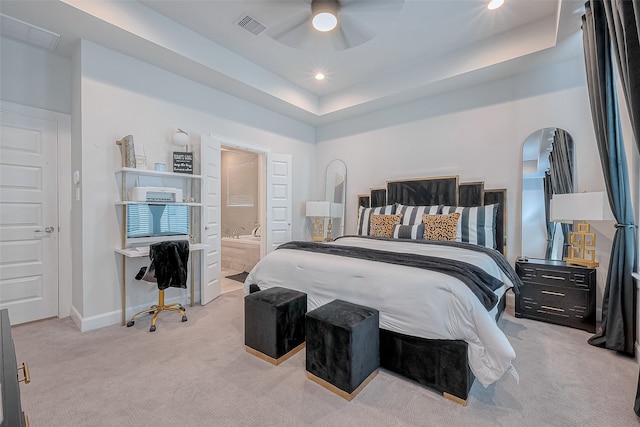 carpeted bedroom featuring ensuite bathroom, ceiling fan, and a raised ceiling